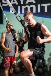 A coach working with a member on the gym floor at Saya Club
